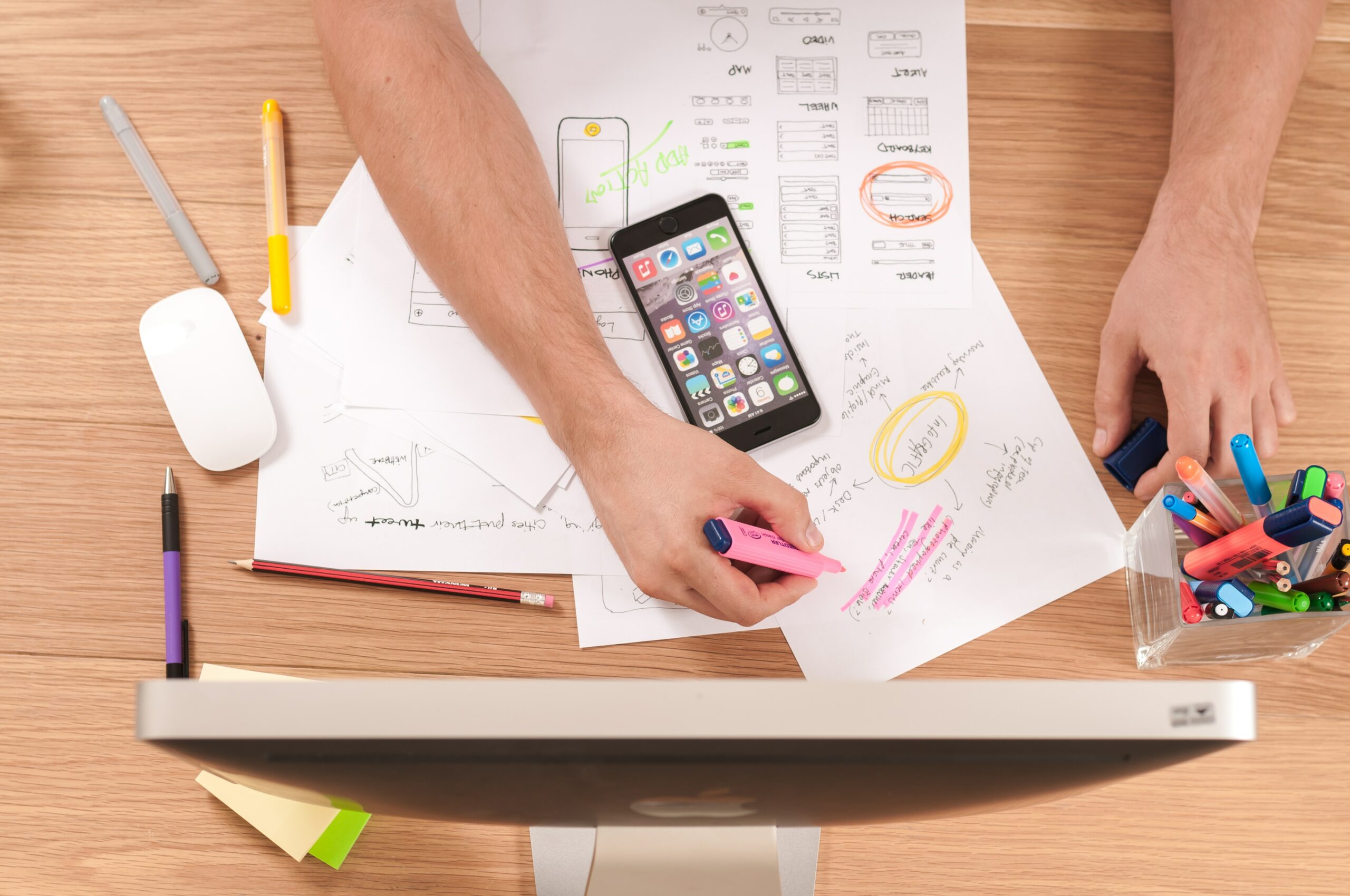 Image of a person working on his desk with papers and phone on table - Destination Certification
